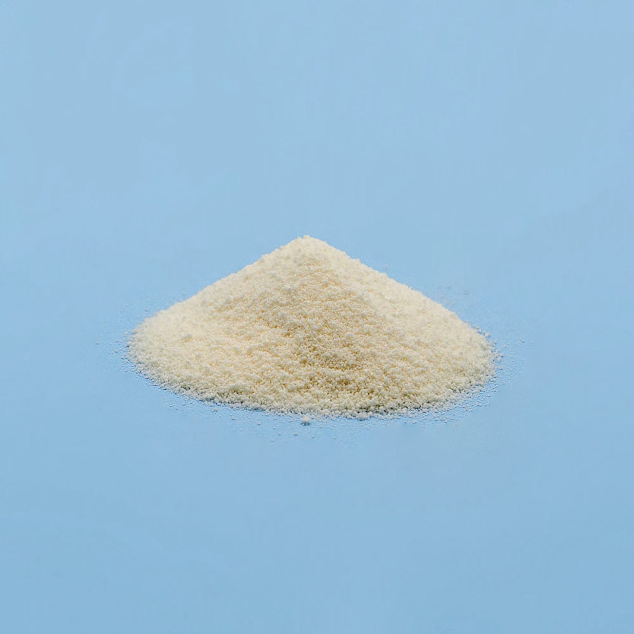Dextrates-Pile of white Dextrates Powder on light blue background-Excipient-Granules