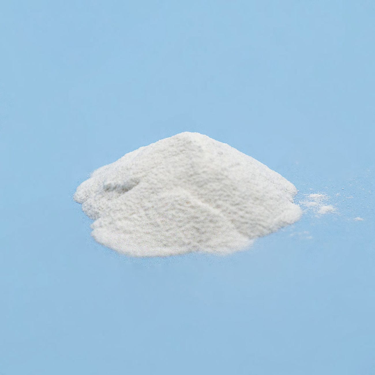 Microcrystalline Cellulose 102-Pile of white Microcrystalline Cellulose 102 Powder on light blue background-Excipient-Granules